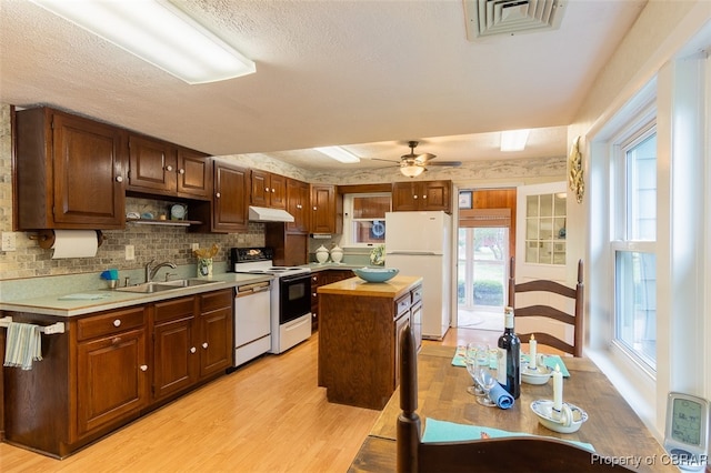 kitchen featuring a healthy amount of sunlight, a center island, and white appliances