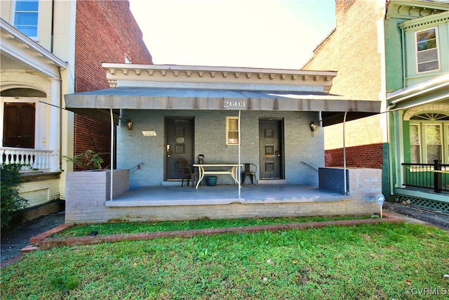 property entrance featuring a porch and a yard