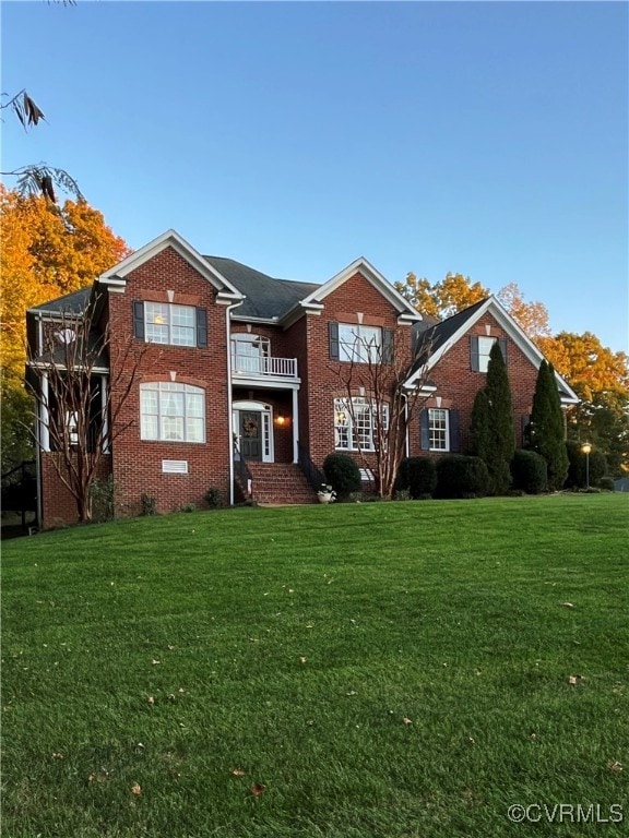 view of front of property with a balcony and a front yard