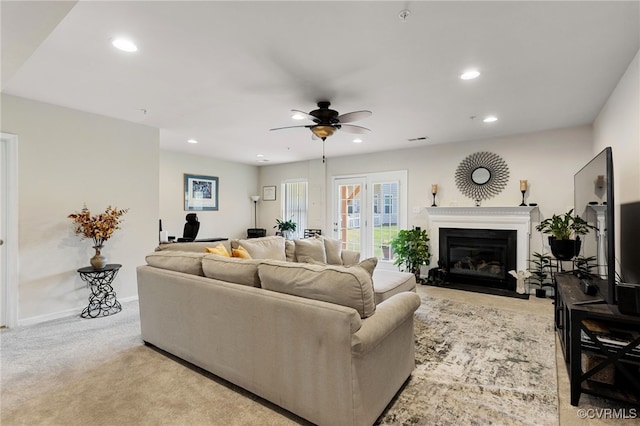 carpeted living room with ceiling fan