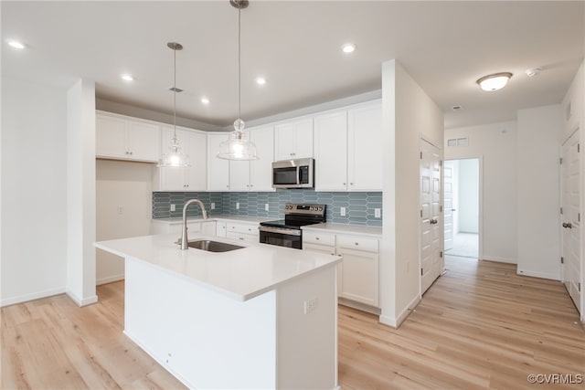 kitchen featuring light hardwood / wood-style floors, a kitchen island with sink, stainless steel appliances, and sink