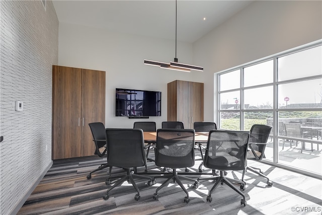 dining space featuring a towering ceiling and dark hardwood / wood-style flooring