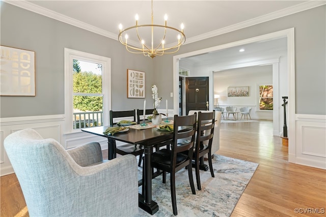 dining area featuring crown molding, a notable chandelier, and light hardwood / wood-style floors