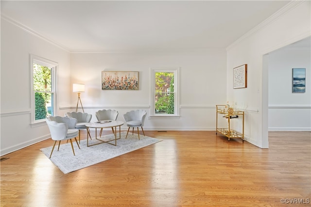 sitting room with crown molding and light wood-type flooring