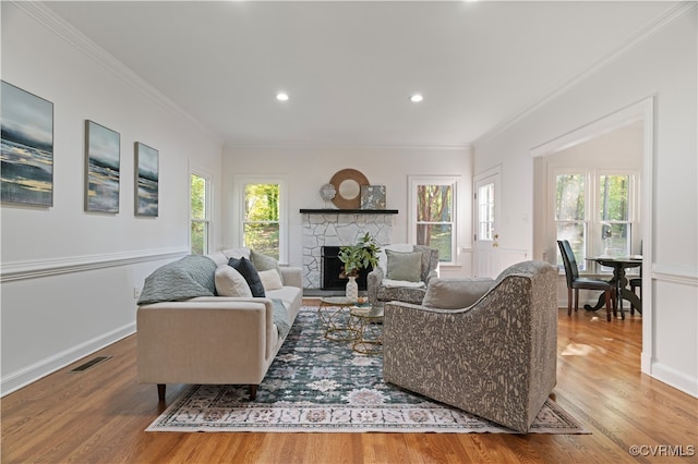 living room with crown molding, wood-type flooring, and plenty of natural light