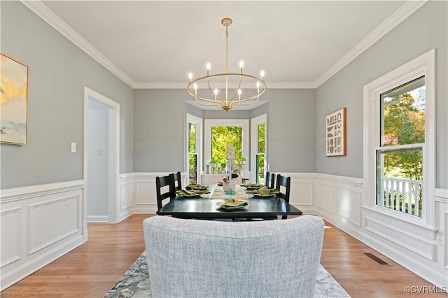 dining space featuring a chandelier, crown molding, and light hardwood / wood-style floors