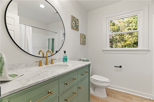 bathroom featuring vanity, toilet, and walk in shower