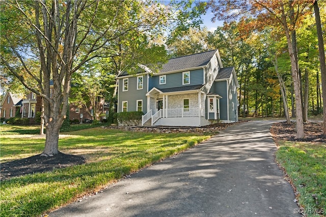 colonial inspired home with a front yard and a porch