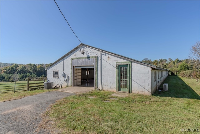 view of front facade featuring central AC and a front yard