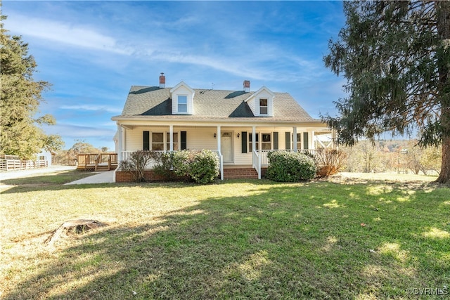 cape cod home with a front yard and covered porch