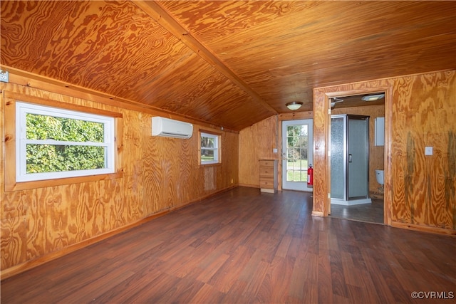 additional living space with dark hardwood / wood-style flooring, wood walls, a wall mounted AC, and vaulted ceiling