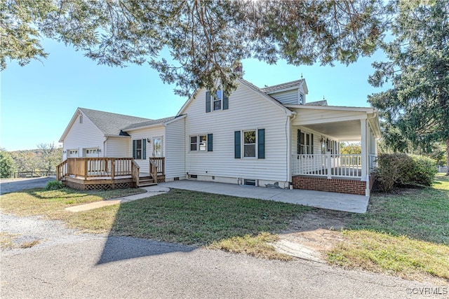 view of front of house with a wooden deck and a front lawn