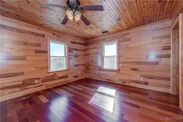 empty room with wood walls, wooden ceiling, hardwood / wood-style floors, and ceiling fan