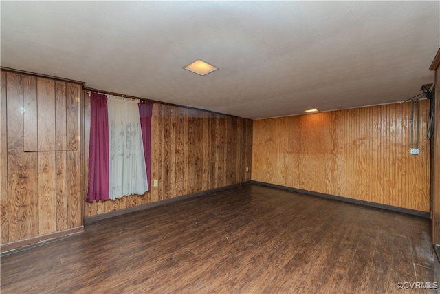 basement featuring wooden walls and dark hardwood / wood-style floors