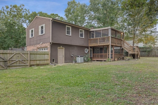 rear view of house featuring central air condition unit, a sunroom, and a lawn