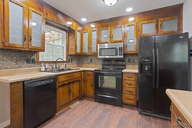 kitchen featuring sink, black appliances, decorative backsplash, and dark hardwood / wood-style flooring