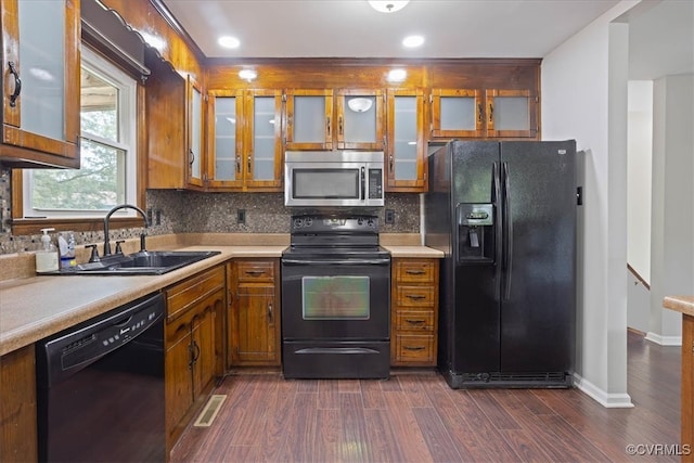 kitchen with decorative backsplash, black appliances, sink, and dark hardwood / wood-style flooring