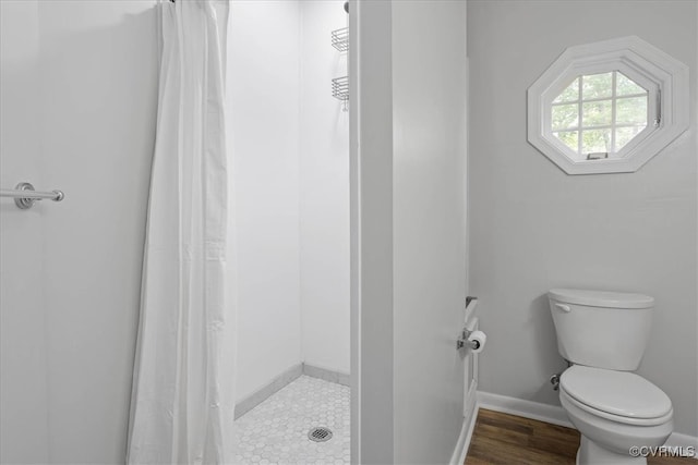 bathroom featuring a shower with curtain, hardwood / wood-style flooring, and toilet