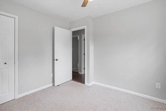 unfurnished bedroom with a closet, ceiling fan, and light carpet