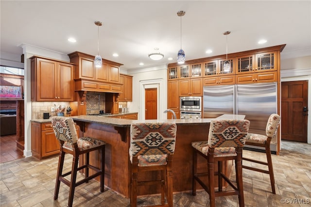 kitchen with built in appliances, light stone counters, tasteful backsplash, and pendant lighting