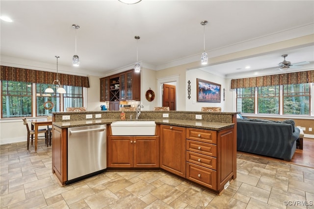 kitchen with decorative light fixtures, a kitchen island with sink, stainless steel dishwasher, and sink