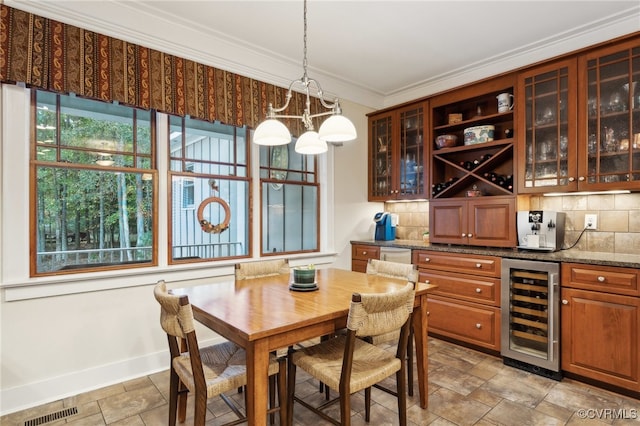 dining room featuring ornamental molding and wine cooler