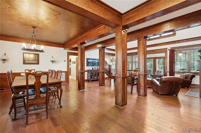 dining room with beam ceiling, a chandelier, ornate columns, and wood-type flooring