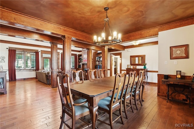 dining area with wood-type flooring and ornate columns