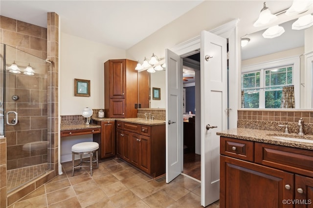 bathroom with vanity, tasteful backsplash, a shower with shower door, and tile patterned flooring