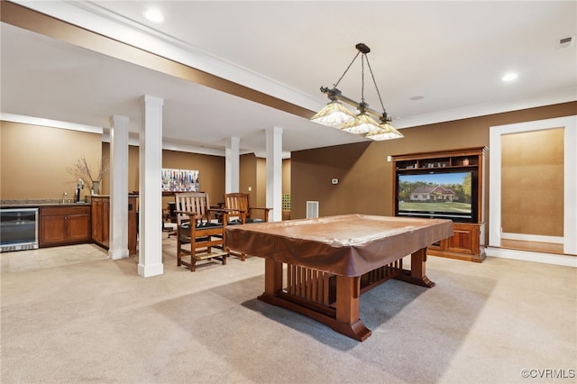 rec room with light carpet, ornamental molding, and beverage cooler