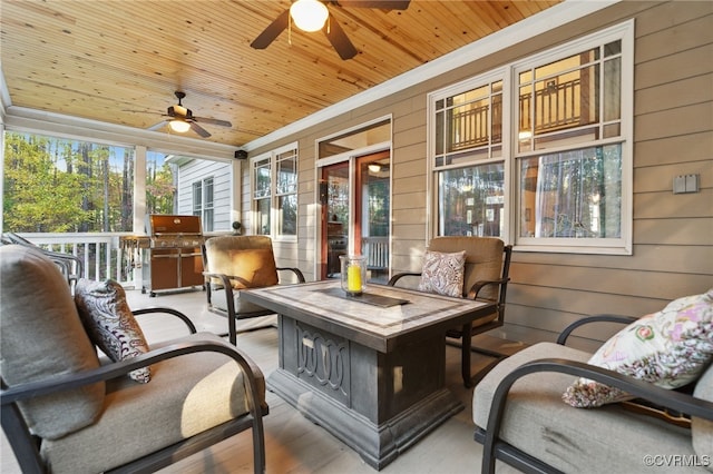 sunroom / solarium with wood ceiling, plenty of natural light, and ceiling fan