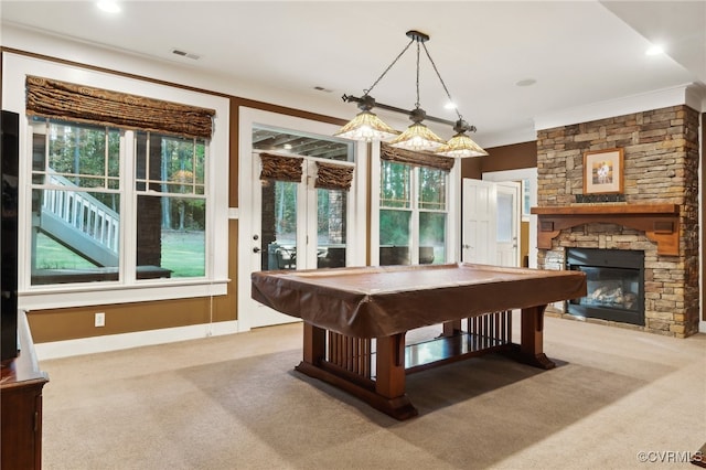 game room featuring crown molding, a stone fireplace, pool table, and light colored carpet