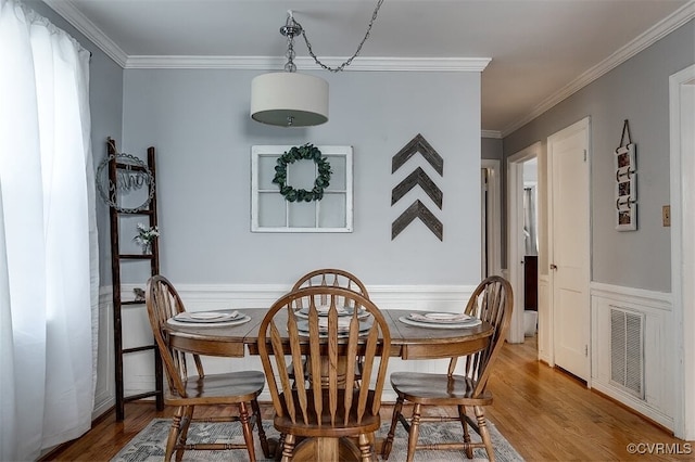 dining area with crown molding and wood-type flooring