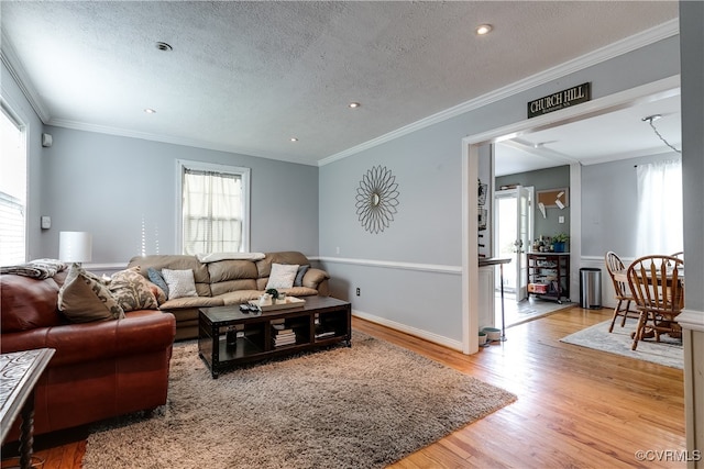 living room featuring crown molding, a textured ceiling, and light hardwood / wood-style flooring