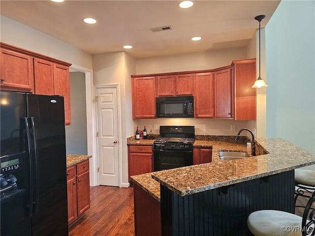 kitchen with pendant lighting, black appliances, sink, dark hardwood / wood-style floors, and kitchen peninsula