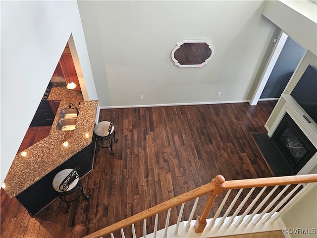 unfurnished living room with dark hardwood / wood-style flooring and sink