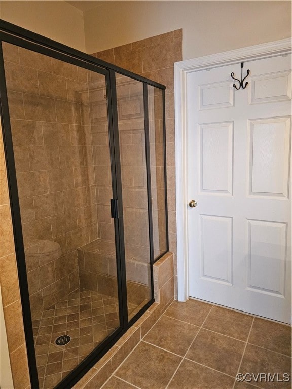 bathroom with tile patterned floors and a shower with shower door