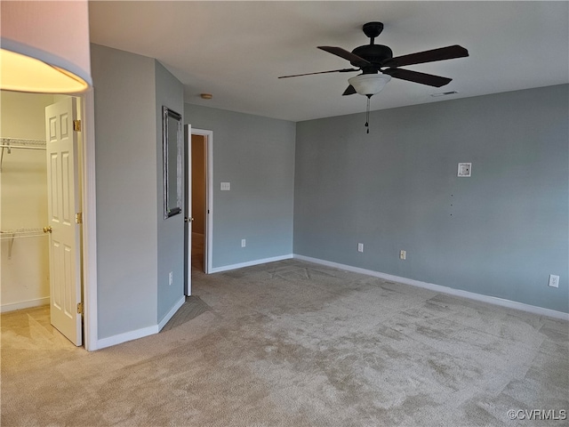 spare room with ceiling fan and light colored carpet