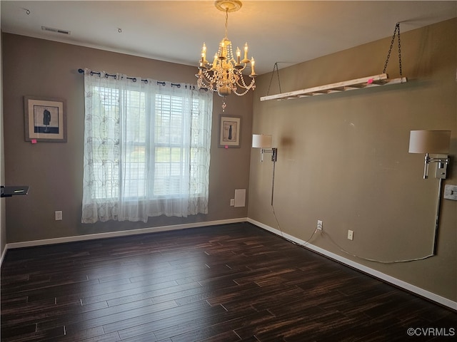 empty room with dark hardwood / wood-style flooring and a chandelier