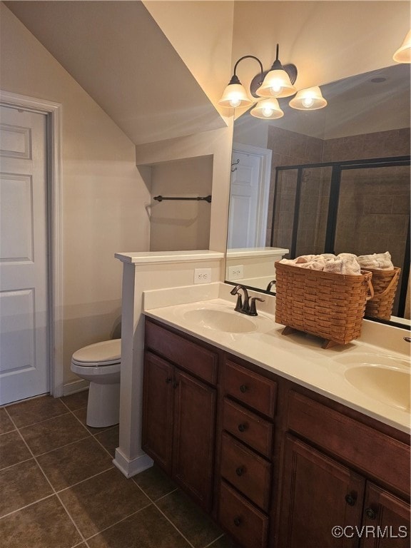 bathroom featuring tile patterned floors, vanity, toilet, and a shower with shower door