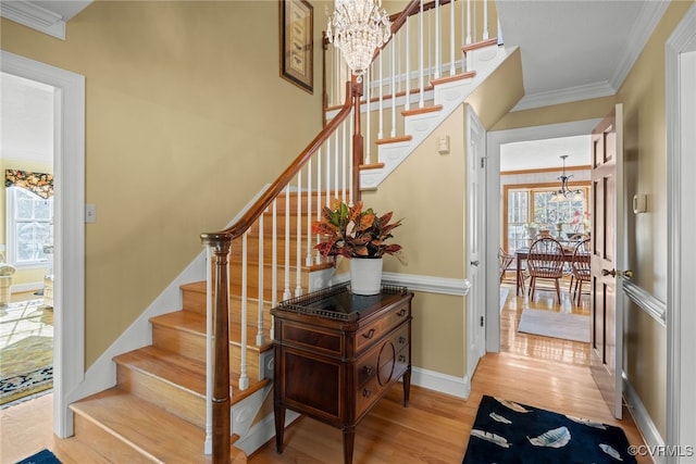 stairs with plenty of natural light, hardwood / wood-style flooring, and a chandelier