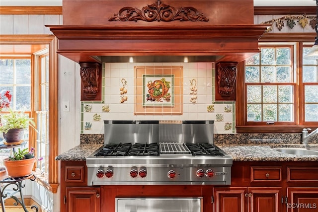 kitchen with decorative backsplash, sink, and dark stone counters