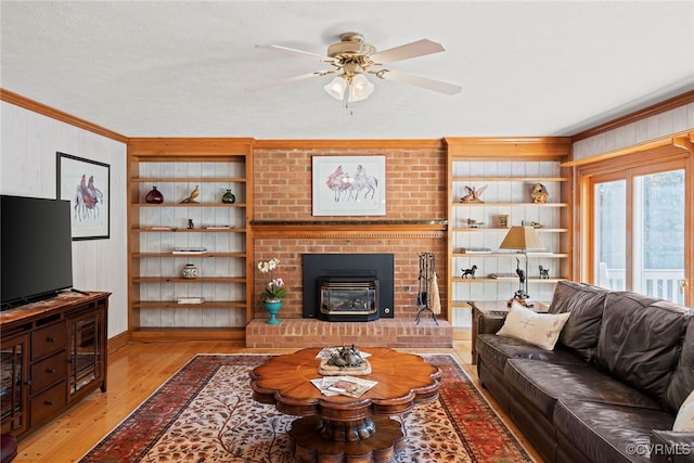 living room featuring crown molding, light hardwood / wood-style flooring, wooden walls, and ceiling fan