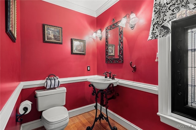 bathroom featuring sink, toilet, wood-type flooring, and ornamental molding