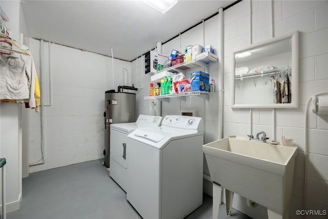 laundry room featuring a textured ceiling, water heater, sink, and separate washer and dryer