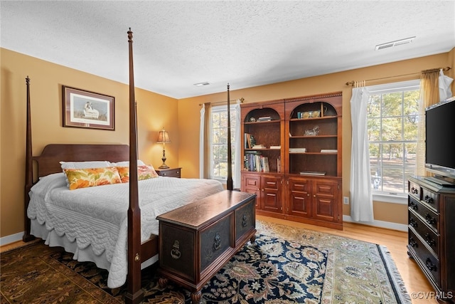 bedroom featuring a textured ceiling and hardwood / wood-style floors