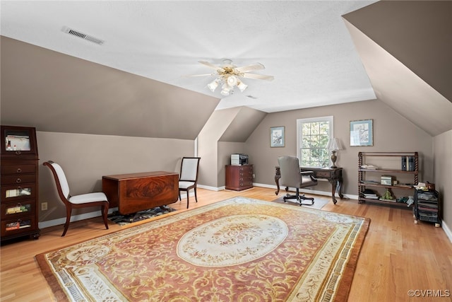 office with a textured ceiling, ceiling fan, wood-type flooring, and vaulted ceiling