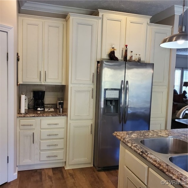 kitchen featuring a textured ceiling, dark stone countertops, ornamental molding, stainless steel fridge with ice dispenser, and dark hardwood / wood-style floors