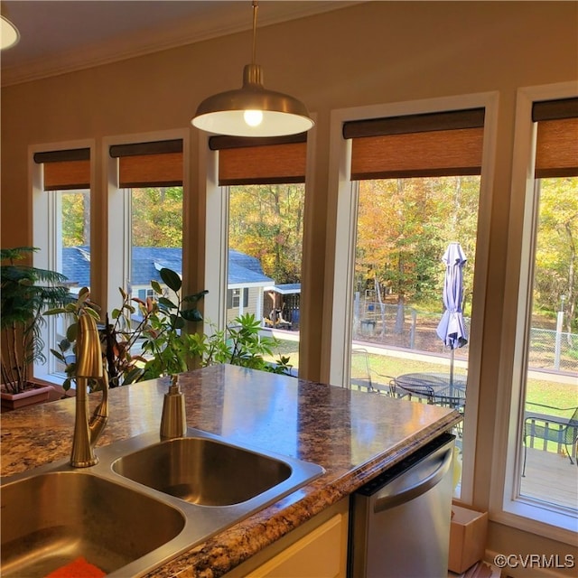 kitchen with sink, dishwasher, a wealth of natural light, and decorative light fixtures