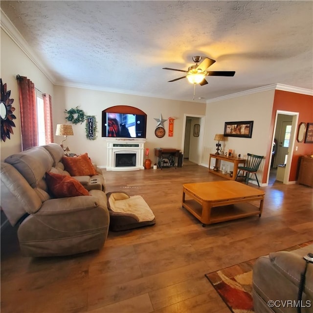 living room featuring crown molding, a textured ceiling, wood-type flooring, and ceiling fan